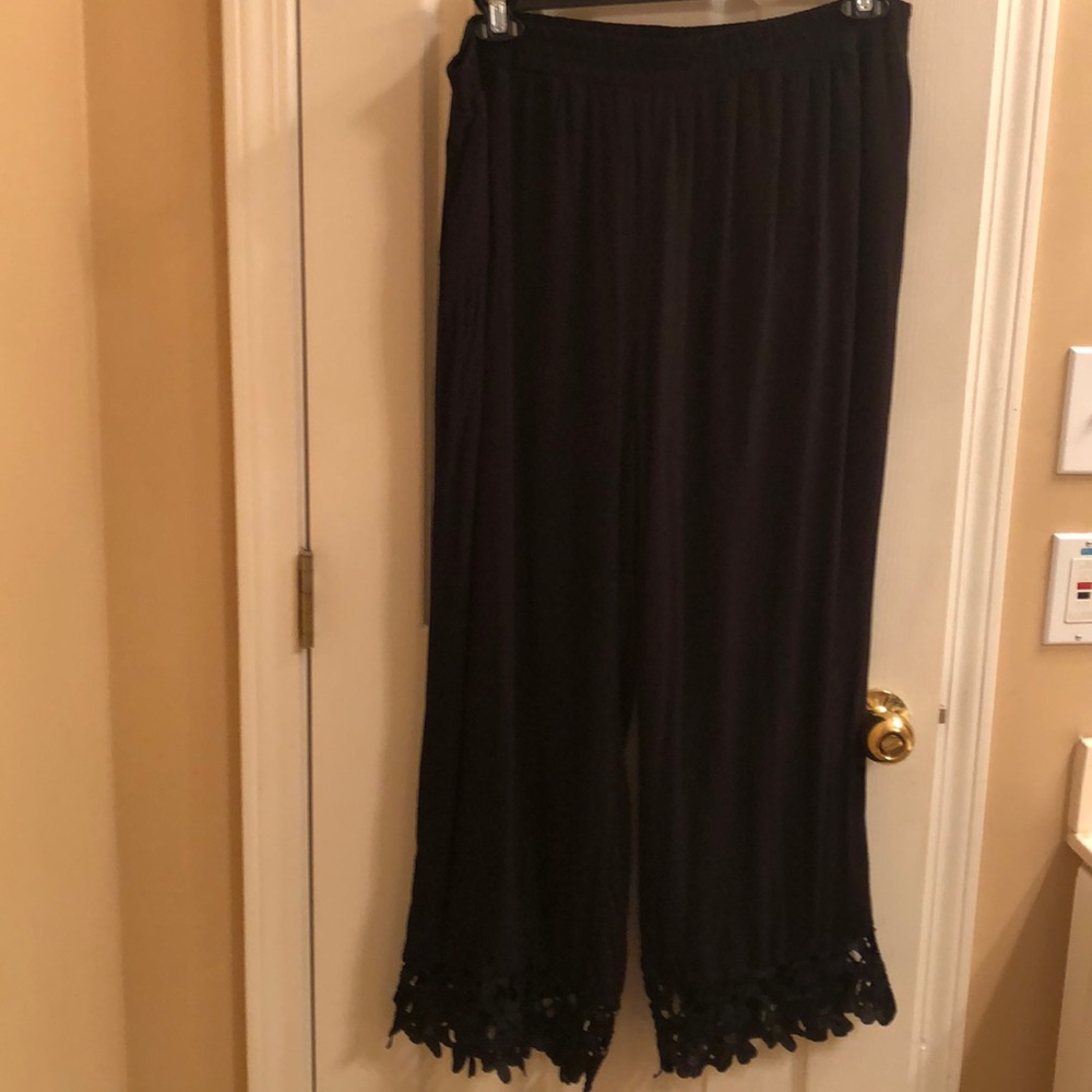 Black linen pants with floral cutout trim on hem